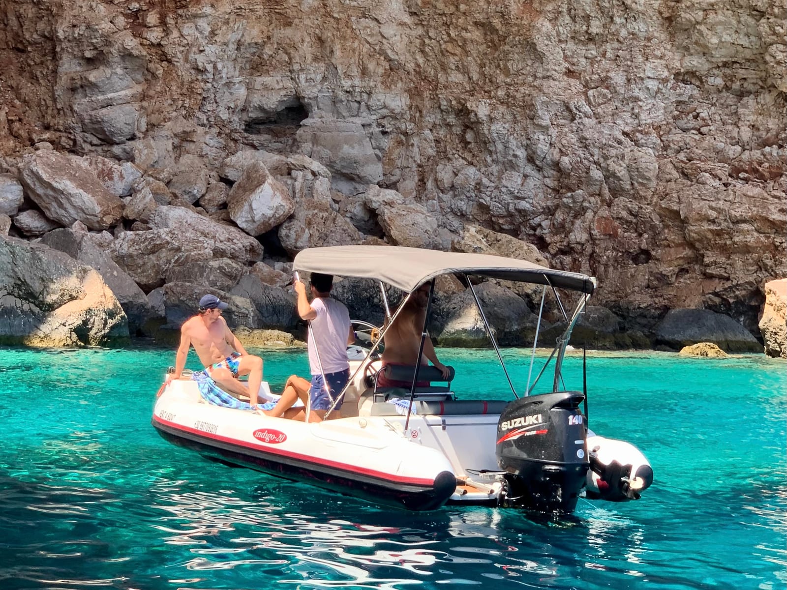 Πήγασος anchored beneath the cliffs in turquoise water